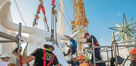 COLOCACION DE LA CABEZA DE BUEY EN LA TORRE DE LLUC , UNA DE LAS CUATRO TORRES DE LOS EVANGELISTAS DE LA SAGRADA FAMILIA QUE RODEARAN LA TORRE DE JESUS.