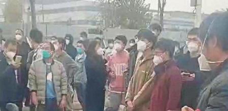 Injured workers sit on the ground during a protest outside Apple supplier Foxconn's factory in Zhengzhou, China November 23, 2022 in this still image obtained by REUTERS from a video. NO RESALES. NO ARCHIVES