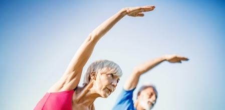 Mature couple exercise outdoors. Side view. Horizontal.