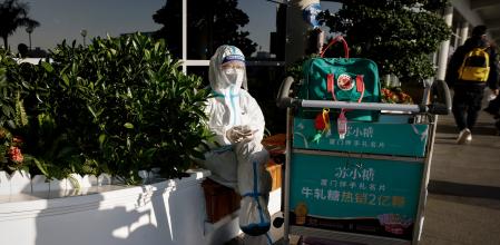 Xiamen (China), 26/12/2022.- A woman wears a protective suit at the Xiamen Gaoqi International Airport in Xiamen, Fujian province, China, 26 December 2022. People from China's two biggest cities; Beijing and Shanghai have returned to work as the country's medical workers continue to battle a surge in Covid-19 with millions of new cases. EFE/EPA/MARK R. CRISTINO