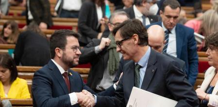 El presidente de la Generalitat, Pere Aragonès (i) y el líder del PSC, Salvador Illa, se saludan durante una sesión plenaria en el Parlament, a 21 de diciembre de 2022, en Barcelona, Catalunya (España). El Parlament vota una proposición de ley de barrios impulsada por los comuns en el último pleno previsto para 2022, mientras el Govern sigue negociando sobre los Presupuestos de la Generalitat con PSC y Junts tras cerrar un acuerdo con los comuns. Además de la ley de barrios, el pleno del Parlament votará este semana un decreto ley de medidas para reducir la temporalidad y fomentar la promoción interna entre los funcionarios y el presupuesto de la Cámara catalana, el Consell de Garanties Estatutàries, la Sindicatura de Comptes y el Síndic de Greuges para 2023. Esta es la última sesión de control del año tras cerrar un acuerdo de Presupuestos con los comuns. 21 DICIEMBRE 2022;CUENTAS;PARLAMENT;PRESUPUESTOS;NEGOCIACIÓN;CUENTAS David Zorrakino / Europa Press 21/12/2022