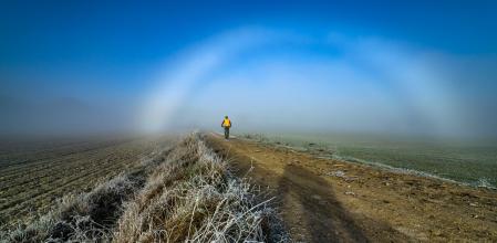 El ciclista pasa por debajo del arco de niebla.
