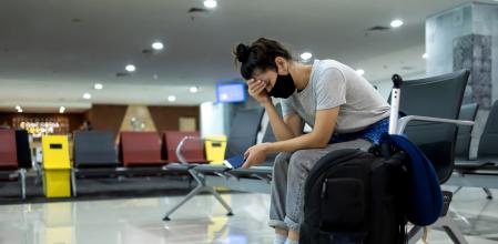 Una joven con una mascarilla en un aeropuerto