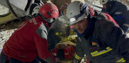 Bomberos durante el rescate de una joven atrapada en los escombros tras el derrumbre de viviendas en Turquía debido al terremoto.