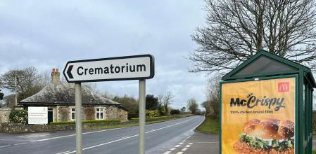 Críticas a un anuncio de comida rápida junto a un cartel de crematorio: “Es de muy mal gusto”