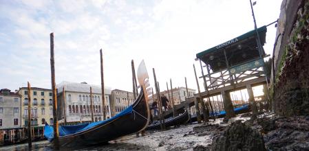 Góndolas embarrancadas en el lodo del fondo de un canal durante la celebración del Carnaval de Venecia