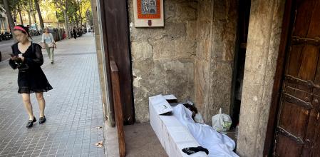 foto XAVIER CERVERA 23/09/2022 un homeless indigente vagabundo sintecho pernocta (con cartones mantas o colchoncito, sabana,.. y tambien un vaso para pedir limosna, asi como bolsa y agua) de manana en l entrada de un restaurante (yantar ribera) de la calle roger de flor, barcelona