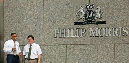 392424 02: Two workers take a cigarette break outside Philip Morris'' New York headquarters July 25, 2001 in New York City. A report commissioned by the Philip Morris company and made public a week ago outlined the financial benefits of smoking on a country''s economy by the
