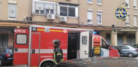 Dotación de bomberos frente al edificio donde ha resultado herida grave una niña al incendiarse su vivienda