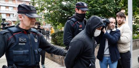 Agentes de la Ertzaintza trasladan al detenido por su presunta vinculación con los asesinatos de hombres en Bilbao tras registrar un piso en la localidad guipuzcoana de Irun.