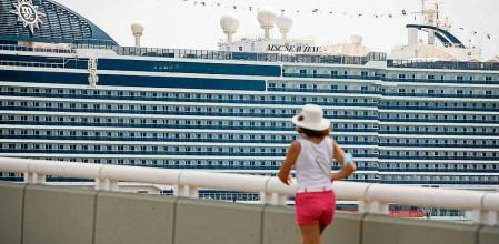 TERMINAL DE CRUCEROS EN EL PUERTO DE BARCELONA. UNA TURISTAS SE DIRIGE A UNO DE LOS BARCOS DESDE EL PUENTE DE LA PUERTA DE EUROPA.