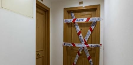 La entrada al piso donde han ocurrido los hechos, precintada por la policía