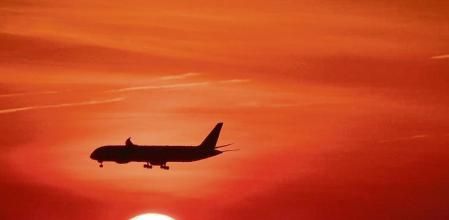 Avión sobrevolando el sol.