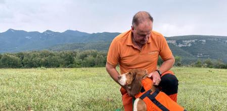 Un caçador amb un dels gossos protegit amb una armilla
