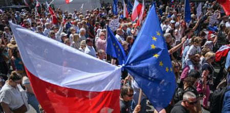 WARSAW, POLAND – JUNE 04: Supporters of opposition parties hold European Union, Polish flags and banners during the Freedom march organized by the main opposition party, Civil Platform leader Donald Tusk on June 04, 2023 in Warsaw, Poland. June 04th is a symbolic date commemorating the first round of partially free parliamentary elections after the fall of communism in Poland. Polish Parliament (SEJM) recently voted on a controversial law to build a commission to investigate Russian influence in Poland, empowering bans on individuals from public office for up to ten years.  The US and EU have raised concerns with the new law and many experts and opposition figures point out that the law, nicknamed 