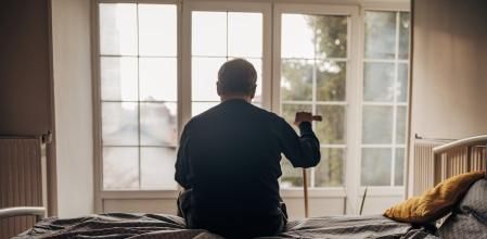 A lonely man is sitting on the bed