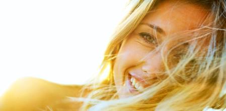 Closeup of happy blond woman with hair flying in wind