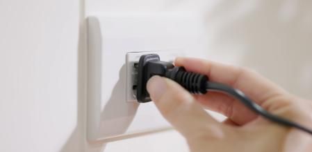 close up shot of plugging in electrical cords socket on the wall