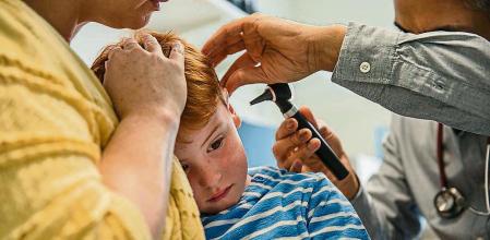 Un médico otorrino examina a un paciente infantil