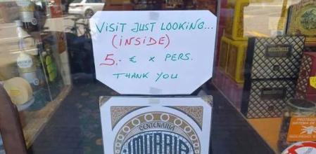 El cartel del colmado que advierte a los turistas que deben pagar 5 euros si solo entran a mirar y hacer fotos