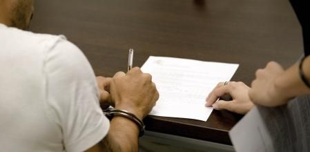 Un detenido por violencia de género firma su declaración.
