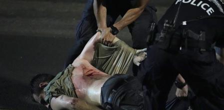 Policías israelíes arrastran a un detenido durante las protestas del lunes por la noche en Tel Aviv