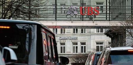 A sign of Credit Suisse bank is seen behind a sign of Swiss banking UBS, in Zurich on March 18, 2023. - Switzerland's largest bank, UBS, is in talks to buy all or part of Credit Suisse, according to a report by the Financial Times. Credit Suisse -- Switzerland's second-biggest bank -- came under pressure this week as the failure of two US regional lenders rocked the sector. (Photo by Fabrice COFFRINI / AFP)