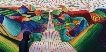 Un joven pasea delante del cartel oficial que celebra el 80 aniversario del Festival de Venecia, que se inaugura hoy