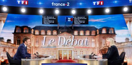 French President and La Republique en Marche (LREM) party candidate for re-election Emmanuel Macron (L) and le French far-right party Rassemblement National (RN) presidential candidate Marine Le Pen (R) sit prior to taking part in a live televised debate on French TV channels TF1 and France 2 in Saint-Denis, north of Paris, ahead of the second round of France's presidential election. - French voters head to the polls for a run-off vote between Macron and Le Pen on April 24, 2022. (Photo by Ludovic MARIN / POOL / AFP)