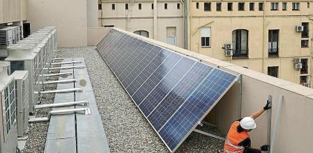 foto XAVIER CERVERA 04/12/2020 un operario trabajador instala placa solar (placas solares) energia fotovoltaica (junto a los aires acondicionados) en lo alto ,azotea, de un nuevo hotel en carrer casp (casi tocando a passeig de gracia) barcelona, donde habia el cine novedades en l antiguedad; durante pandemia coronavirus