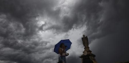 Una mujer se protege de la lluvia en Córdoba a mediados de septiembre.&nbsp;