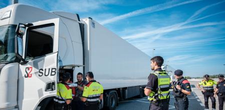 Mossos de Trànsit analizan la documentación de un transportista en presencia de un funcionario de aduanas, ayer