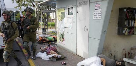 Soldados israelíes junto a civiles muertos en el ataque de Hamas a Sderot, Israel, esta mañana