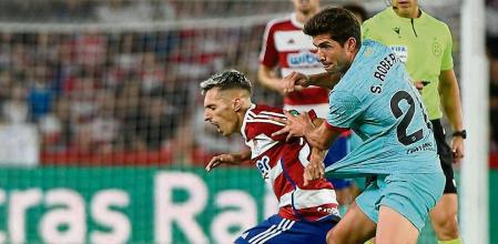 GRANADA, 08/10/2023.- El delantero del Granada, Bryan Zaragoza (i), cae ante el centrocampista del FC Barcelona, Sergi Roberto, durante el encuentro correspondiente a la jornada nueve de primera división que disputan hoy Domingo en el estadio Nuevo Los Cármenes, en Granada. EFE / Miguel Ángel Molina.