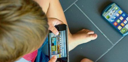 25 - 08 - 2012 / Centelles / Nino Niño juega con telefono movil y mira internet en lugar de otros juguetes tradicionales / Foto: Llibert Teixido