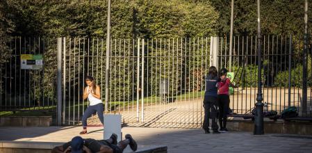 Varias personas hacen deporte ante la cancela del Turó Park, a la espera de que la abran