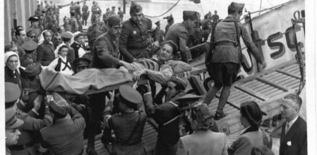 Un soldado herido es subido a uno de los barcos aliados que le devolverán a su país