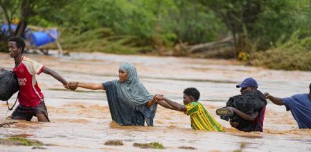 Residents cross a road damaged by El Niño rains in Tula, Tana River county in Kenya on Friday, Nov. 25, 2023. Severe flooding in the country has killed at least 71 people and displaced thousands, according to estimates from the UN Office for the Coordination of Humanitarian Affairs. (AP Photo/Brian Inganga)