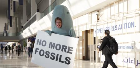 DUBAI, UNITED ARAB EMIRATES - DECEMBER 03: An environmental activist dressed as a dugong, a sea creature native to the United Arab Emirates, holds a sign that reads: 