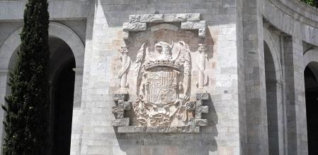 El águila de San Juan se distingue de las demás porque tiene una aureola de santo en la cabeza, y, en el escudo de los Reyes Católicos, las alas plegadas. Aquí el escudo en Cuelgamuros
