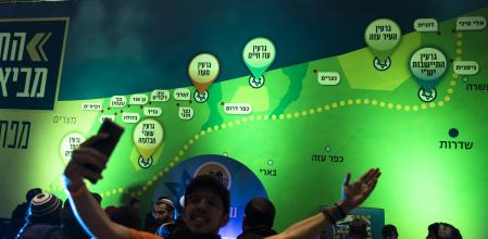JERUSALEM, ISRAEL - JANUARY 28: A man takes a photo with a map showing the Gaza Strip with Jewish settlements during a convention calling to resettle the Gaza Strip and northern West Bang at the  International Convention Center on January 28, 2024 in Jerusalem, Israel. In the months since Oct. 7, various right-wing politicians and activists have called for creating new Jewish settlements in the Gaza Strip, which Israel previously occupied until 2005, at which time it dismantled its existing settlements and pulled out Israel Defense Forces. Talk of creating new Jewish settlements in Gaza has drawn opprobrium from the international community, including Israel's allies like the United States. (Photo by Amir Levy/Getty Images)
