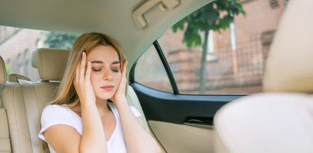 Una mujer con dolor de cabeza en el coche.