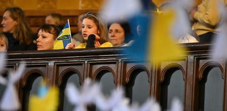 Young attendees are pictured through some 528 paper angels, said to represent the number of children killed in Ukraine sice the beginning of the invasion by Russia, during an Inter-faith Prayer Service for peace in Ukraine, at the Ukrainian Catholic Cathedral in London, on February 24, 2024, during a service to mark 2 years since the beginning of the invasion. (Photo by Ben Stansall / AFP)