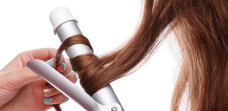 Primer plano de un rizador de pelo en uso.