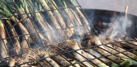 Las 'calçotades' populares se organizan en las plazas y calles del barrio