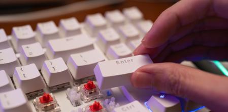 Una persona customizando su teclado mecánico para el ordenador.