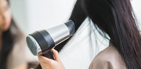 Una persona secándose el pelo.