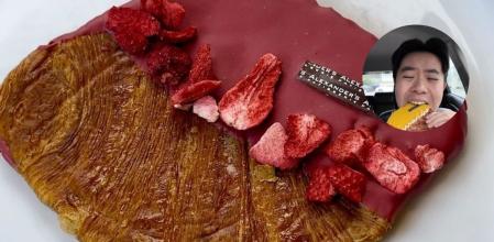 Un cruasán plano con cobertura de fresa.