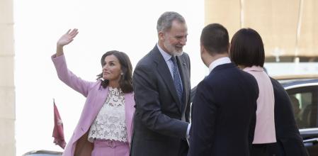 El rey Felipe VI saluda a las autoridades mientras la reina Letizia saluda al público congregado ante el Palau Ducal dels Borja, en Gandia.