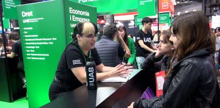 Una chica informando a alumnos de secundaria sobre las posibles carreras que tiene en la UAB